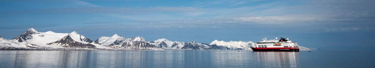 Die MS Fram fährt auf Expeditions-Seereise in Spitzbergen. Im Hintergrund sind Eisberge.