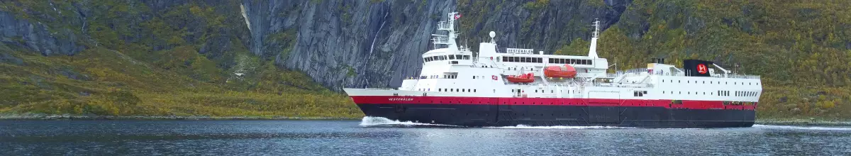 Schiff auf dem Meer mit grünen Bergen im Hintergrund