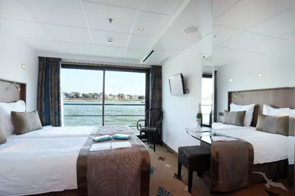 Außenkabine auf der MS Alina mit französischem Balkon, Doppelbett und großem Spiegel.