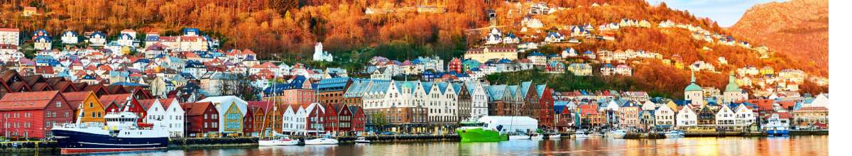 Bergen: Hafenpanorama mit bunten Häusern direkt am Ufer des Fjordes im Herbst.