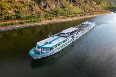 Die MS Swiss Crystal fährt an einem Weinberg entlang.