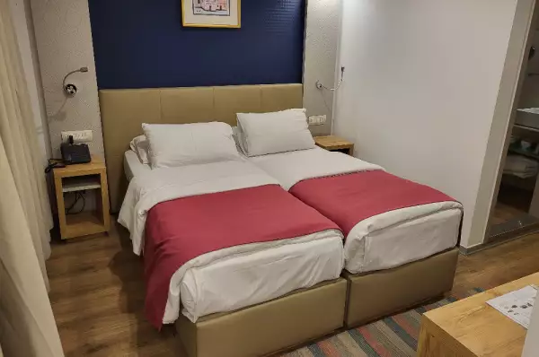 Zweibettkabine der Queens Vision Man sieht ein Kabinenbeispiel einer 2-Bett-Kabine. Sie ist ausgestattet mit zwei Betten und grundsätzlich schlichter Dekoration.