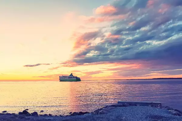 Ostsee-Kreuzfahrt Ein Kreuzfahrtschiff fährt über die Ostsee bei Sonnenuntergang.
