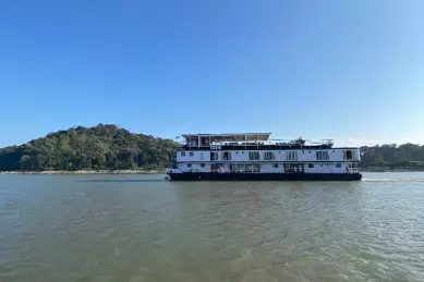 Die MS Sukapha fährt über einen Fluss durch Indien.