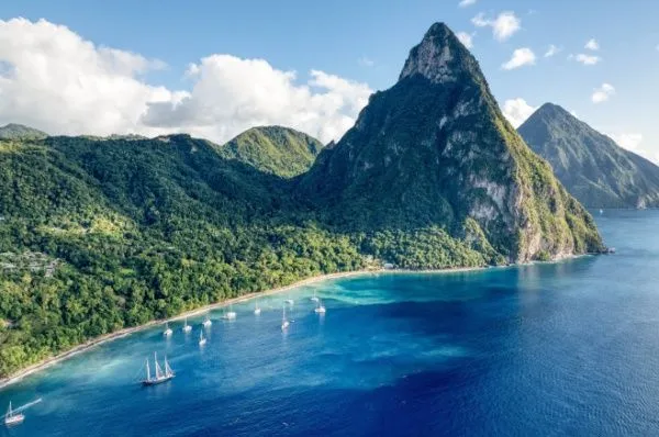 Spektakuläre Naturwunder als Grund für eine Karibik-Kreuzfahrt Luftaufnahme der beeindruckenden Pitons auf St. Lucia, ein Grund für eine Karibik-Kreuzfahrt. Die spitzen, üppig grünen Vulkanberge ragen aus dem blauen Meer empor und stehen für die Entdeckung weltberühmter Naturwunder und spektakulärer Landschaften.