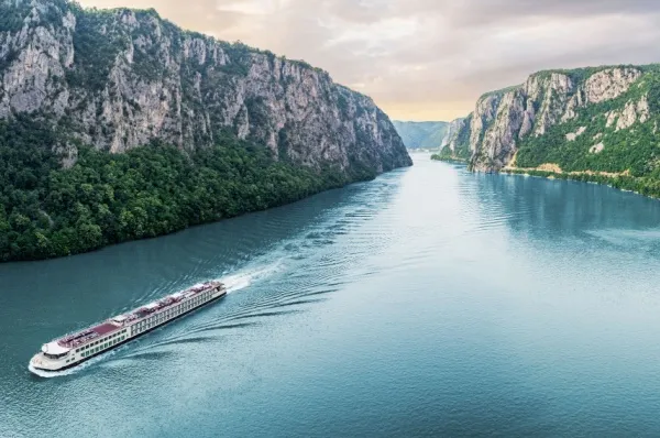 Eisernes Tor – Flusskreuzfahrt Ein Flusskreuzfahrtsschiff fährt entlang der Donau durch ein Tal.