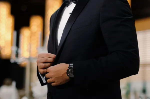 Der Oberkörper eines Mannes ist in formaler Kleidung, also Anzug mit Hemd und Fliege gekleidet.