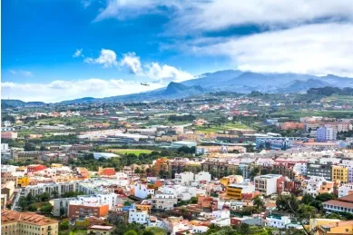 Die Stadt Teneriffa von oben mit sommerlichem Wetter und einem Berg im Hintergrund.