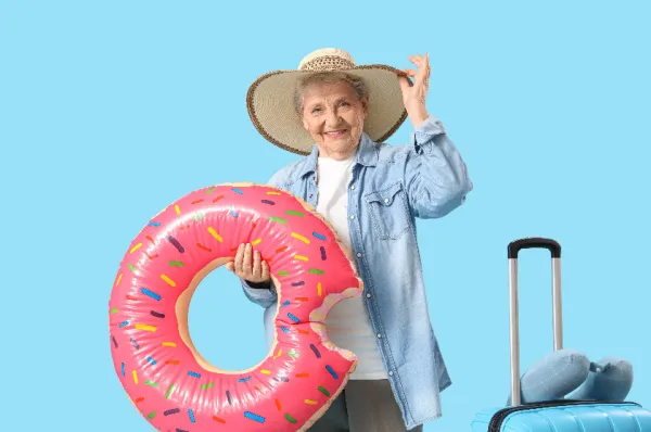 Eine reisefertige Seniorin mit Koffer und einem lustigen Schwimmring zeigt die Vorfreude auf eine Seniorenkreuzfahrt. Das Bild symbolisiert den Spaß und die gute Laune bei der Reisevorbereitung für einen Urlaub auf See.