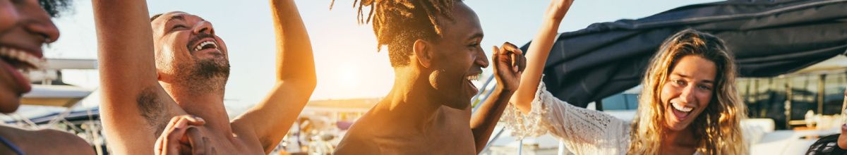 Fröhliche Menschen tanzen und lachen an Deck unter der Sonne während der Event-Kreuzfahrt AIDA tanzt 2027.