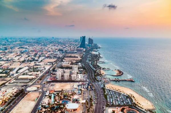 Luftaufnahme einer modernen orientalischen Küstenstadt bei Sonnenuntergang, Symbol für eine unvergessliche Orient Kreuzfahrt zur besten Reisezeit.