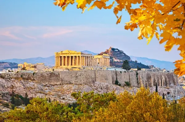 Akropolis im Herbst Blick auf die Akropolis in Athen, umgeben von bunten herbstlichen Bäumen.