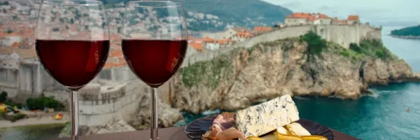 Zwei Gläser Rotwein mit Blick über eine Küste – Getränkepakete bei Costa.