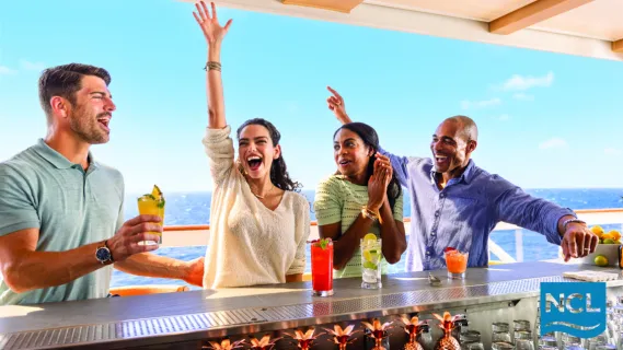 Fröhliche Gäste genießen farbenfrohe Cocktails an einer Poolbar an Bord von Norwegian Cruise Line mit Blick auf das offene Meer.