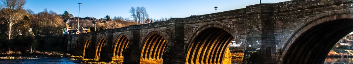 Alte Steinbrücke über einem Fluss bei Sonnenuntergang in Aberdeen.