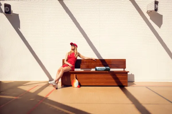 Eine Frau entspannt auf dem Pickleballfeld der Cunard Line: Sie hat ihre Reise im Smart Tarif gebucht und clever bei der Kreuzfahrt gespart.