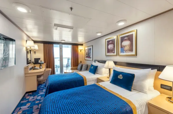 Eine Britannia Club Balkonkabine auf der Queen Elizabeth der Cunard Line, mit edlem, dunkelblauem und weißem Interieur.