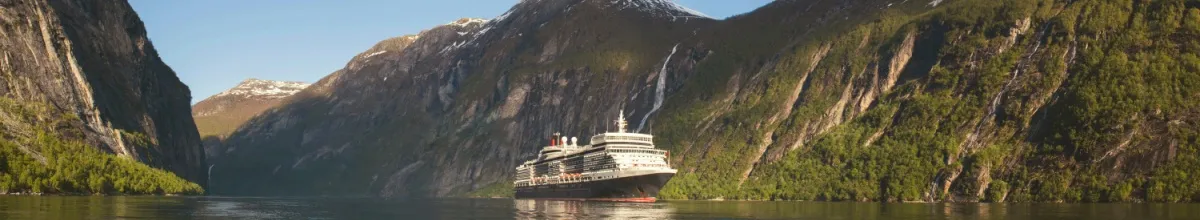Seitenperspektive des Kreuzfahrtschiffs Queen Elizabeth bei Dämmerung.