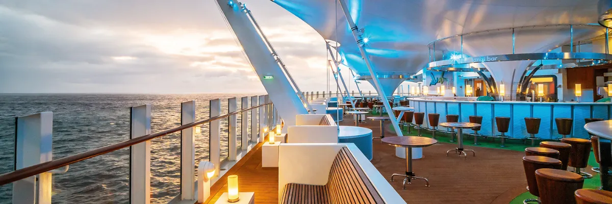 AIDA Evolution: Lanai Bar und Open-Air-Lounge mit Meerblick Stilvolle Lanai Bar auf dem Außendeck mit Meerblick im Abendlicht an Bord im Rahmen von AIDA Evolution.