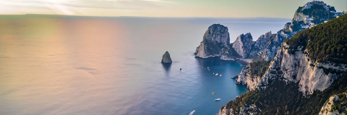 Die Felsformation Faraglioni vor der Küste Capris im Sonnenaufgang.