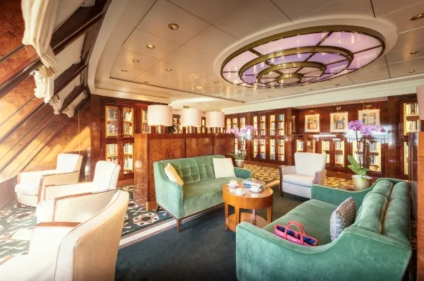 Queen Mary 2 Bibliothek Die Bibliothek an Bord der Queen Mary 2 bietet Ihnen Platz, Ruhe und genug Bücher, damit Sie sich auf Ihrer Kreuzfahrt vollkommen entspannen können.
