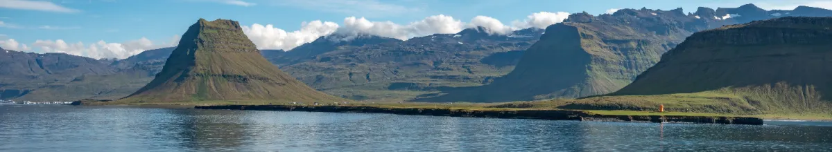 Eine Bergkette an Islands Küste bei Tag.
