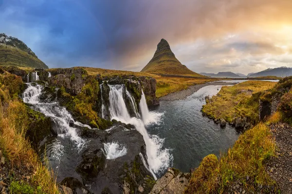 Malerische Berge und ein Wasserfall bei Sonnenuntergang in Island, Grundarfjörður.