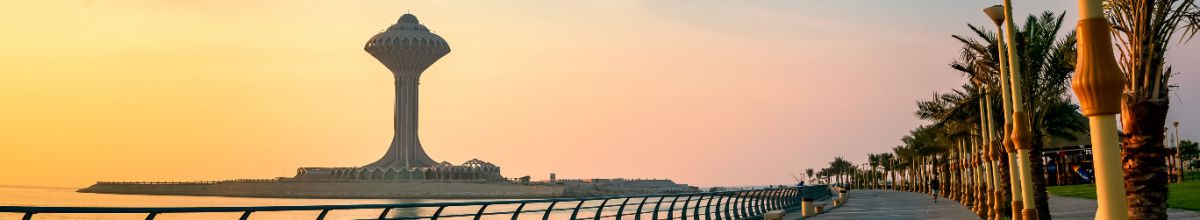 Ein futuristischer Wasserturm auf einer Insel bei Sonnuntergang mit Palmen