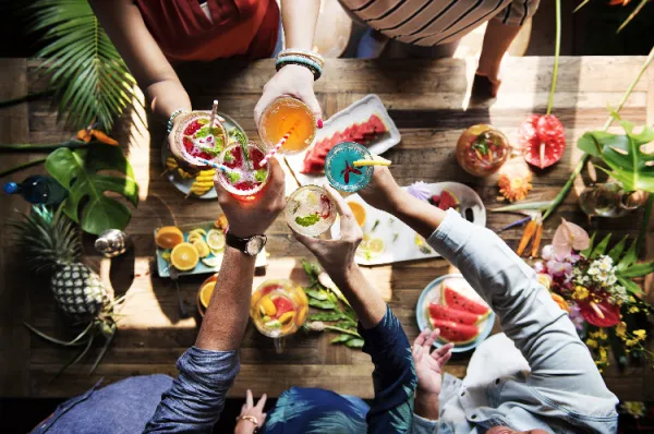 Tropische Früchte und Drinks Leute die mit tropischen Cocktails anstoßen und weitere exotische Früchte nebenbei