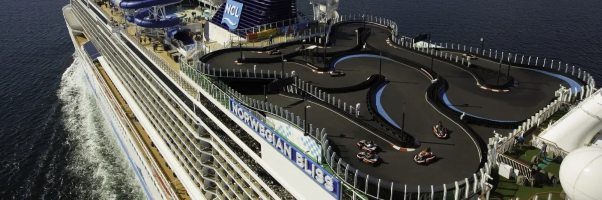 Kartbahn auf dem Kreuzfahrtschiff Auf dem oberen Deck der Norwegian Bliss befindet sich eine zweistöckige Kartbahn mit Blick auf das Meer.