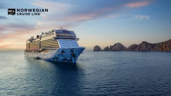 Norwegian Bliss auf Kreuzfahrt Die Norwegian Bliss fährt übers Meer und entfernt sich langsam von den Bergen von Cabo San Lucas in Mexiko.