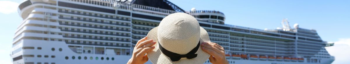 Die Seitenansicht eines Kreuzfahrtschiffes mit einer Frau mit Hut im Vordergrund