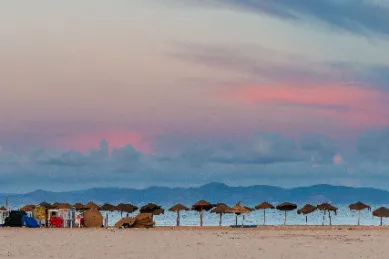 Strandaufnahmen in La Goulette während der Abenddämmerung mit rötlichem Himmel und dem Meer im Hintergrund.