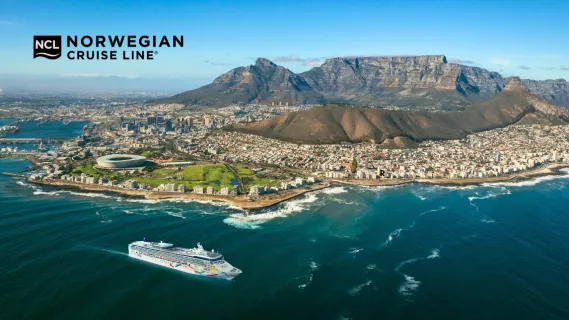 Norwegian Dawn Seitenansicht der Norwegian Dawn vor Kapstadt in Südafrika mit der Stadt im Hintergrund.