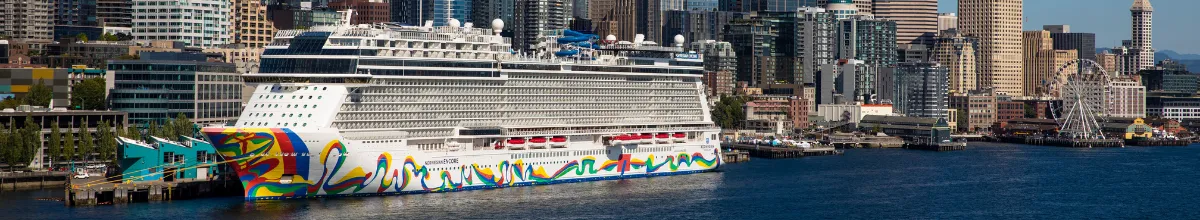 Seitenansicht der Norwegian Encore vor dem Hafen in Seattle, Washington. Das bunte Design am Burg fällt auf.
