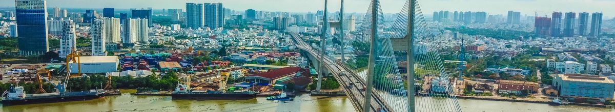EIne Totale der Metropole Phu My bei Tag mit einer Vielzahl an Wolkenkratzern und der bekannten Phu My Bridge.