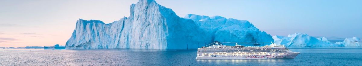 Norwegian Star fährt über das arktische Meer. Im Hintergrund sind Eisberge zu sehen.