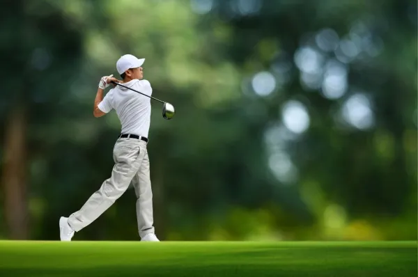 Ein Mann spielt Golf auf einem begrünten Golfplatz. Spielen auch Sie auf der nächsten Golf-Kreuzfahrt von AMADEUS Flusskreuzfahrten.