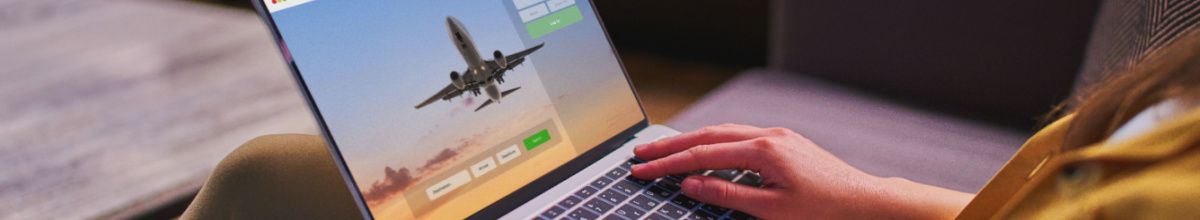 Eine Frau die eine Reise an ihrem Laptop plant.