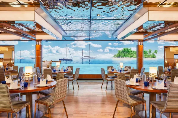 Das Yachtclub Restaurant auf der AIDAnova mit Ausblick aufs Meer, verspiegelter Decke und modernem Design.