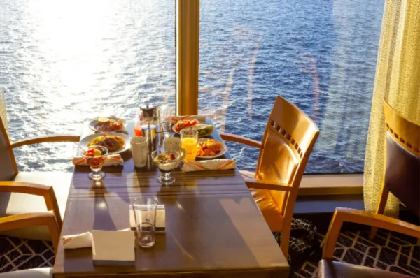 Aussicht von einem Bordrestaurant aufs Meer mit einem gedeckten Tisch.