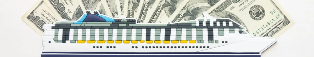 Modell eines Kreuzfahrtschiffes auf einem Fächer aus Geldscheinen als Symbol für Bordguthaben und die Finanzierung einer Kreuzfahrt.