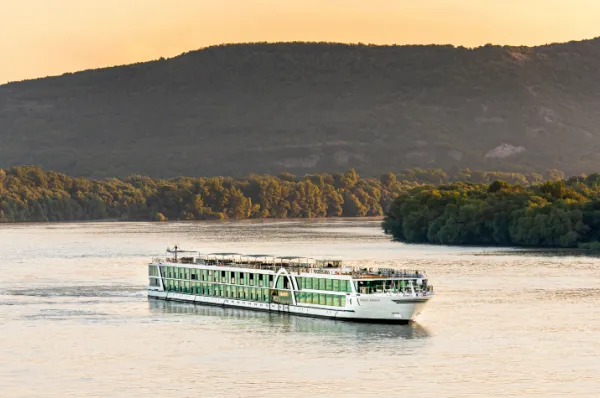AMADEUS Flusskreuzfahrtschiff im goldenen Abendlicht auf dem Weg durch Europa, komfortable Flusskreuzfahrt auf Rhein, Main und Mosel