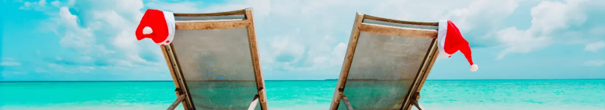 Weihnachtliche Dekoration mit Weihnachtsmannmütze am tropischen Strand, Symbol für eine besondere Feiertagskreuzfahrt und attraktive Reiseangebote.