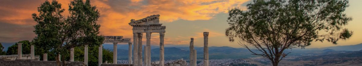 Überreste einer alten Ruine bei Izmir inmitten eines Olivenhaines bei Sonnenuntergang.