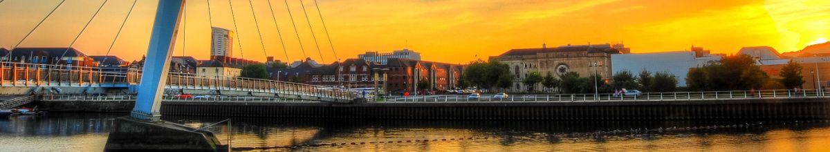 Totale der Stadt Swansea von der Hafenkante aus bei Dämmerung.