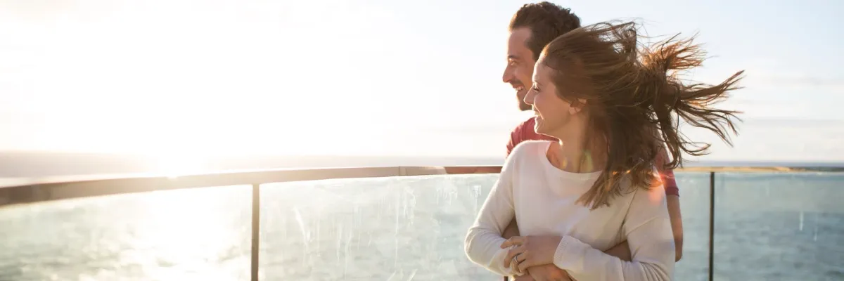 Unvergessliche Transreisen mit der Kussmundflotte Ein Pärchen steht an der Reling eines AIDA Schiffes und blickt auf den Ozean