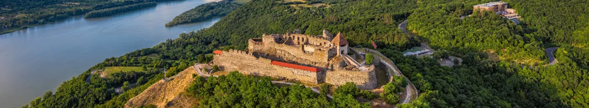 Luftaufnahme der alten Visegrád Burg bei Tag umringt von Wäldern.