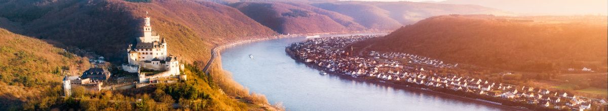 Luftaufnahme der Marksburg in Braubach mit dem Rhein bei Abenddämmerung.