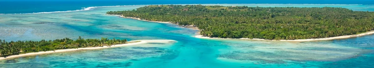 Luftbild der grünen Insel Sainte Marie, die von türkisblauem Meer umgeben ist.